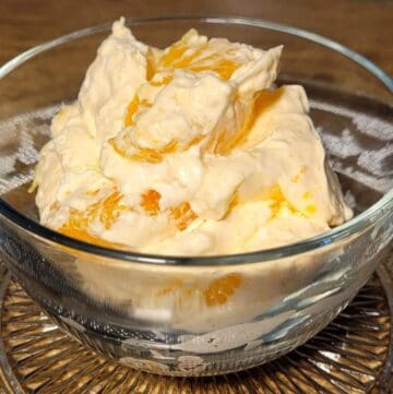 grandmas orange cool whip dessert in a one person serving dish with cool whip, mandarin oranges, cottage cheese and orange flavored Jell-O