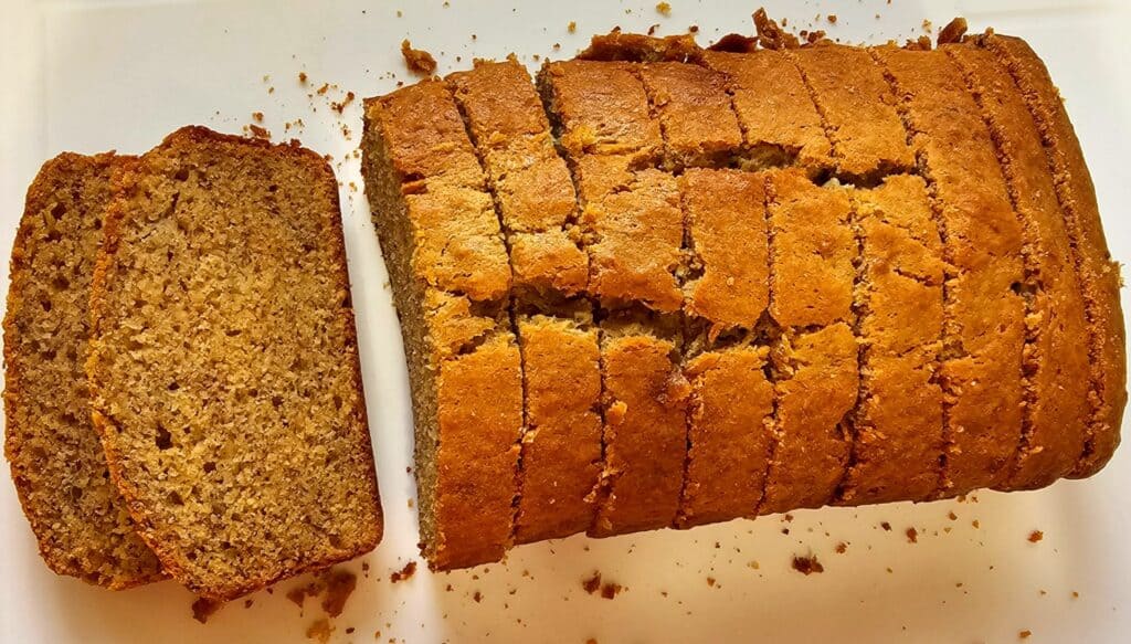 old fashioned banana bread sitting on a cutting board thats sliced