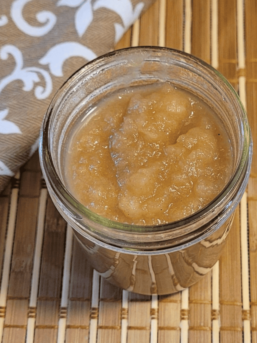 homemade apple sauce in a small mason jar placed on a bamboo mat