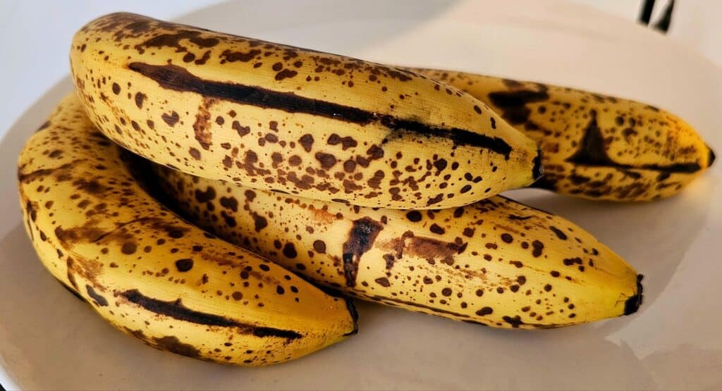 a bundle of ripe bananas for baking old fashioned banana bread that have brown spots on them