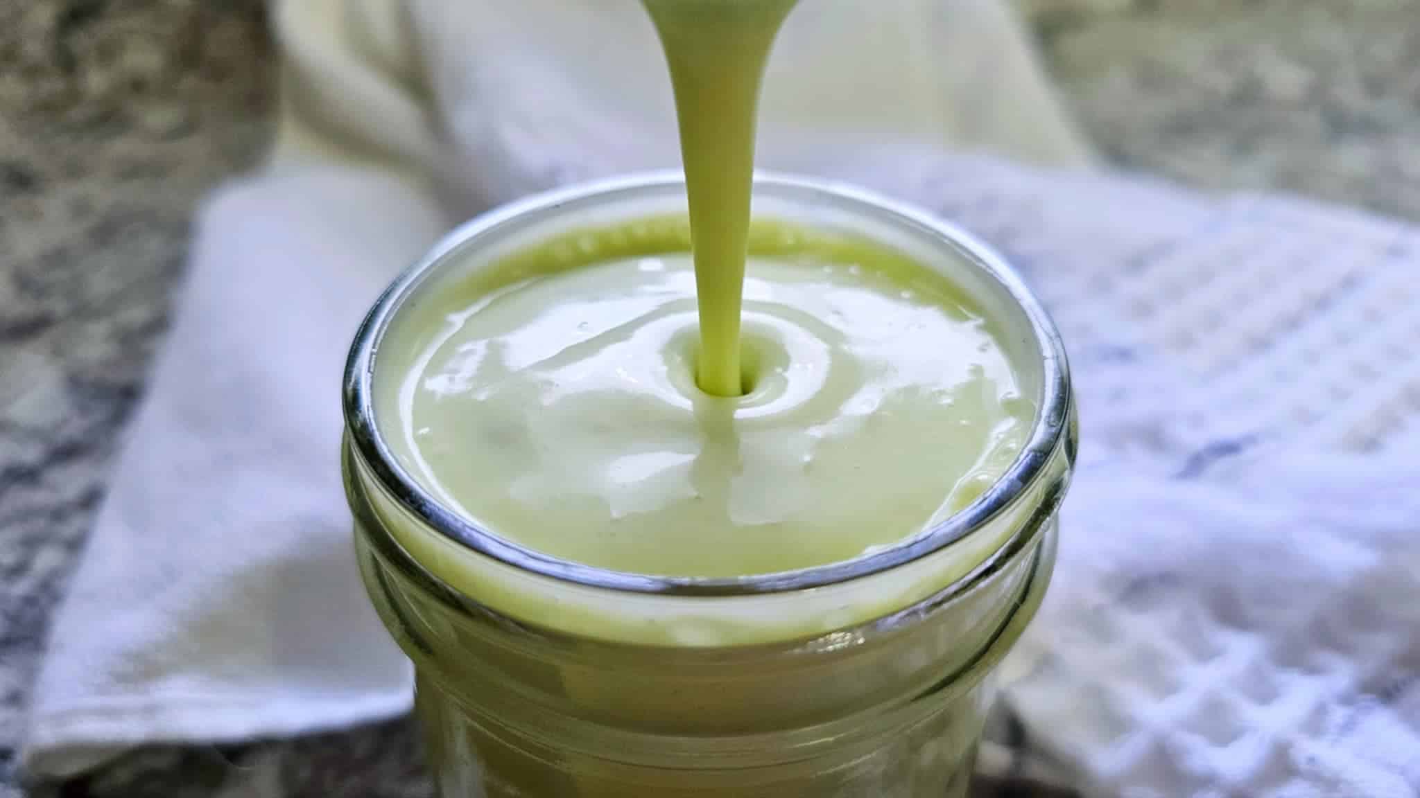 Quick Creamy Avocado Dressing Recipe (Vegan Option) being poured into a mason jar