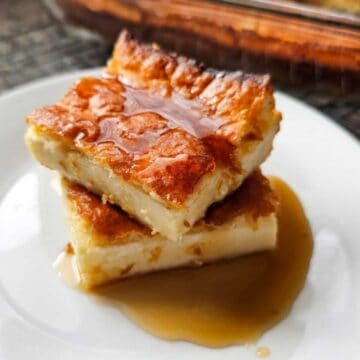 Pannukakku (Finnish Oven Baked Pancake Recipe) sitting on a plate and drizzled with pure maple syrup
