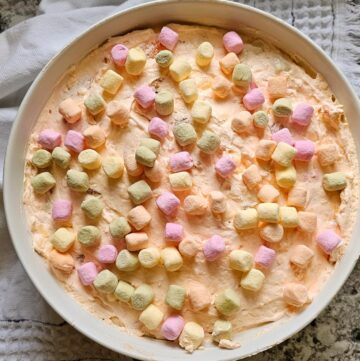 Easter Fluff in a white bowl made with cool whip, canned fruit, marshmallows and cottage cheese