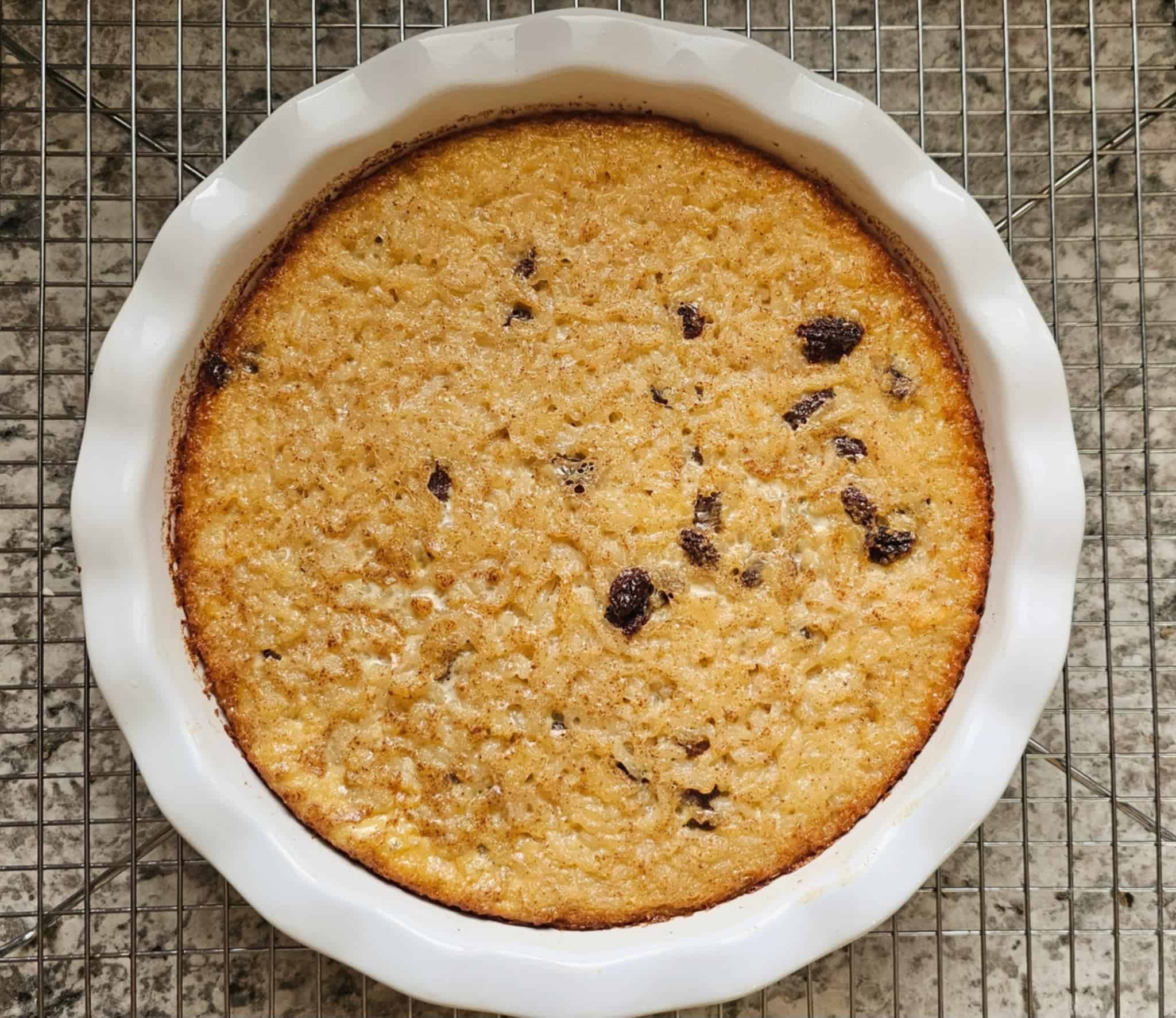baked rice custard on a wire rack cooling in a deep ceramic pie dish