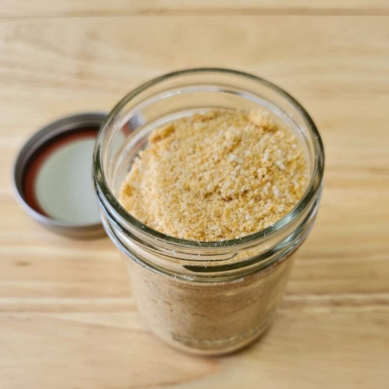 Bread crumbs sitting in a small mason on a wooden counter