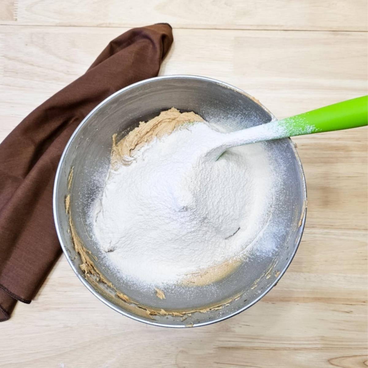 wet ingredients with dry ingredients sifted over them
