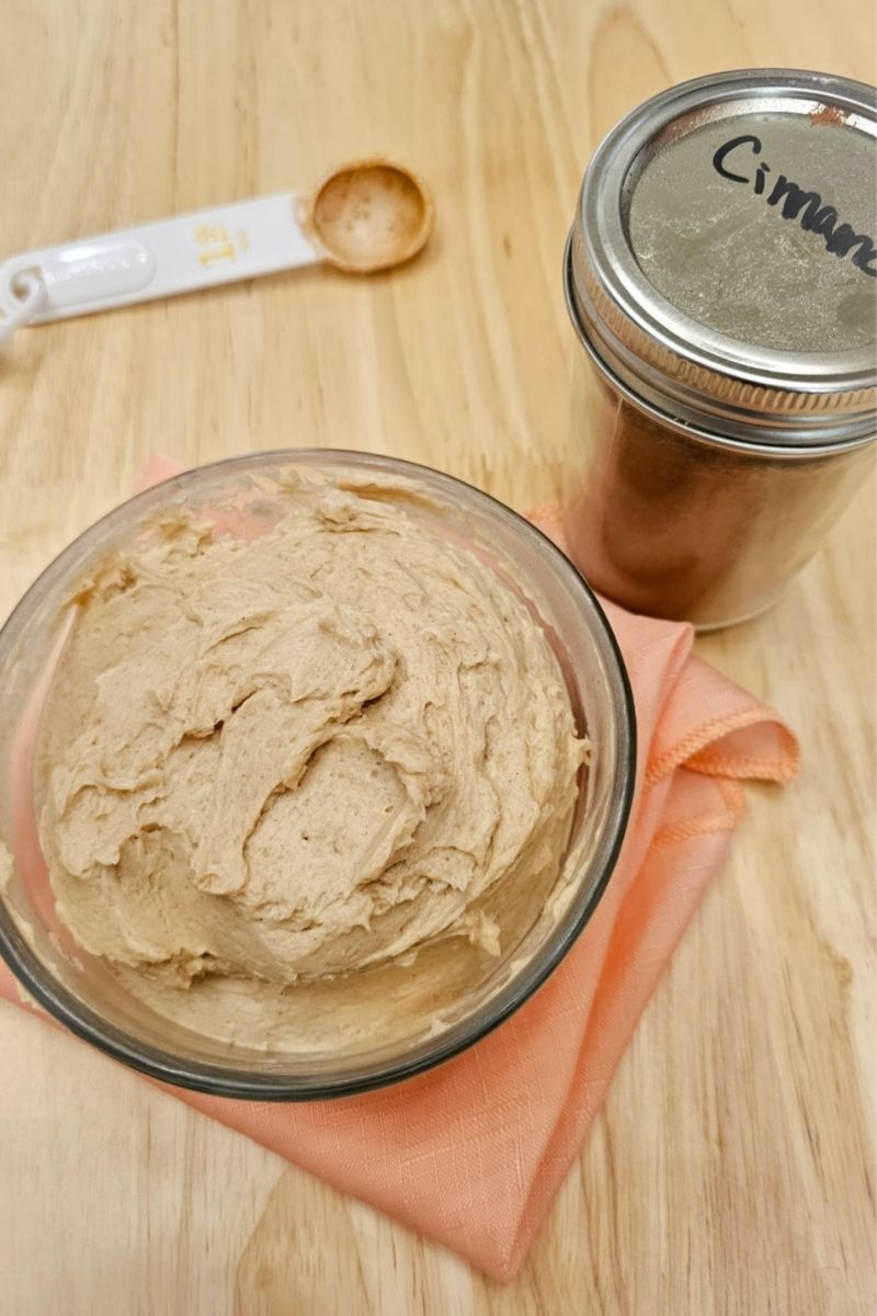 cinnamon in a mason jar on a counter top next to a bowl of butter with cinnamon and honey
