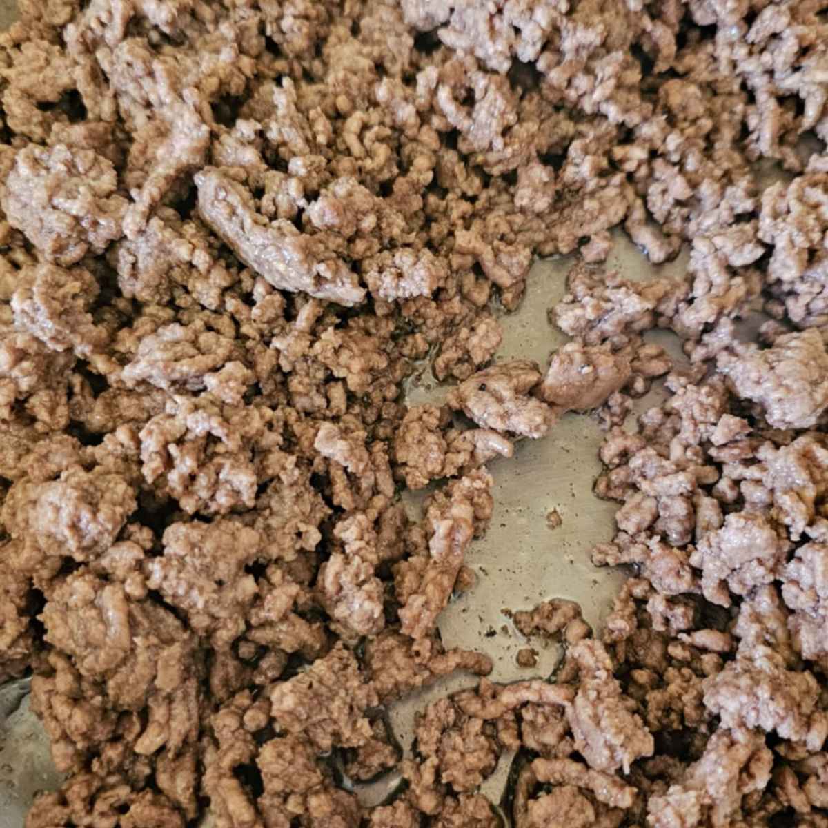 cooked ground beef in a stainless steel pan