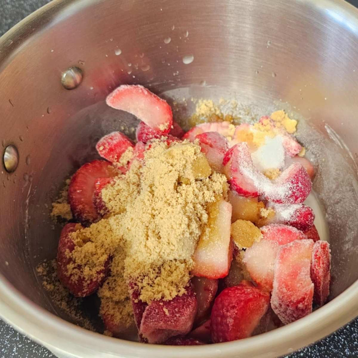 frozen strawberries in a pot with sugar, lemon juice and cornstarch