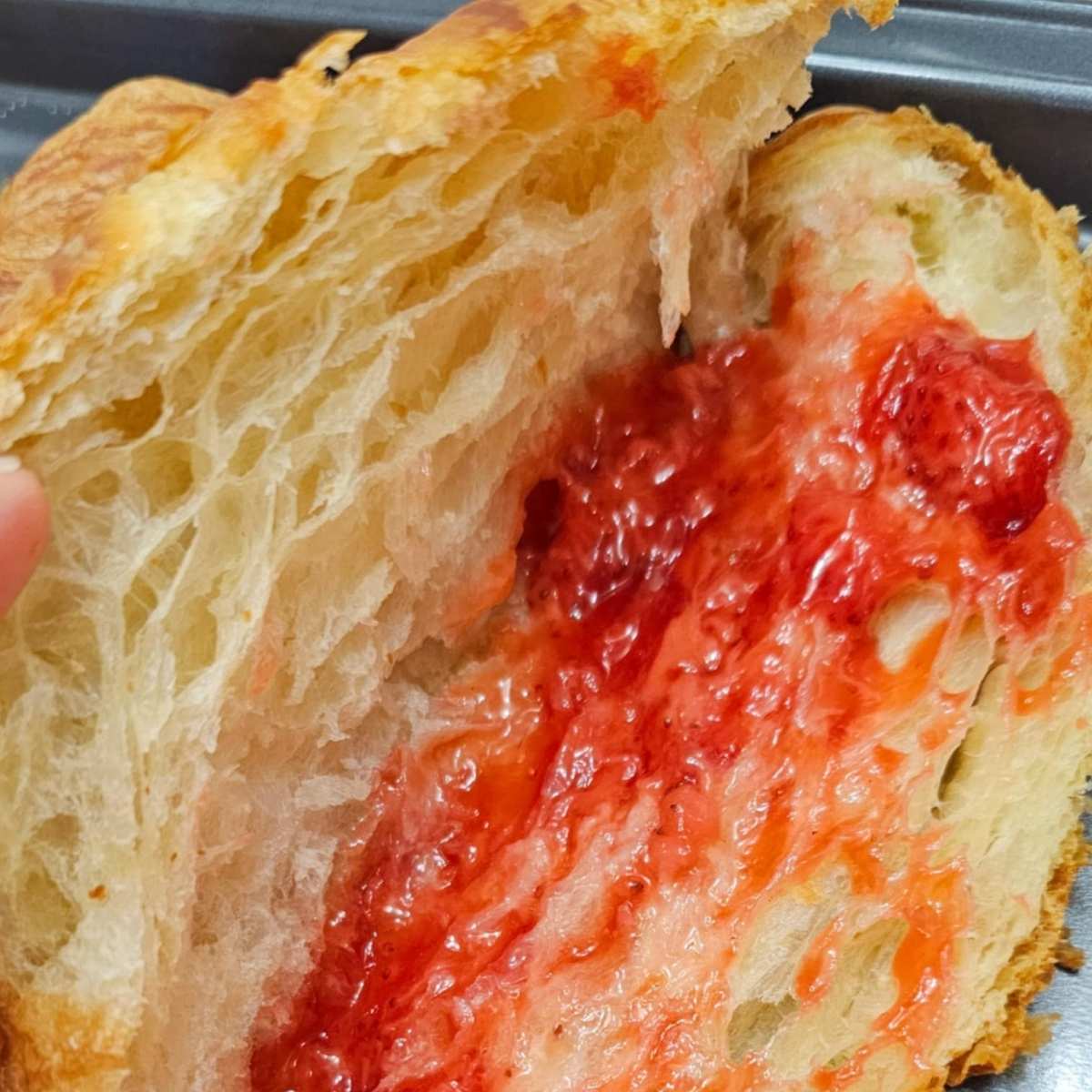 homemade strawberry sauce added to strawberries and cream croissant