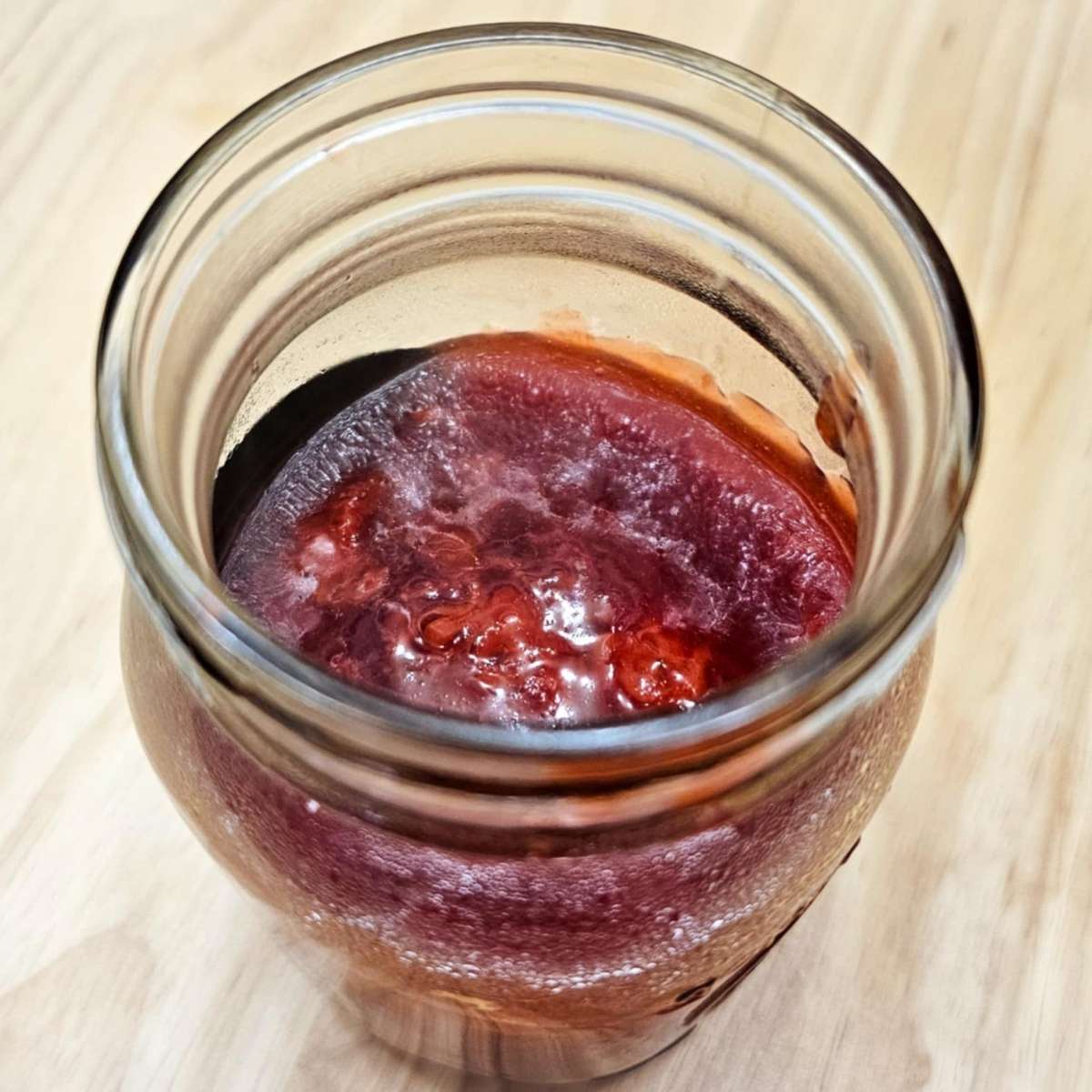 strawberry jam cooling down in a mason jar