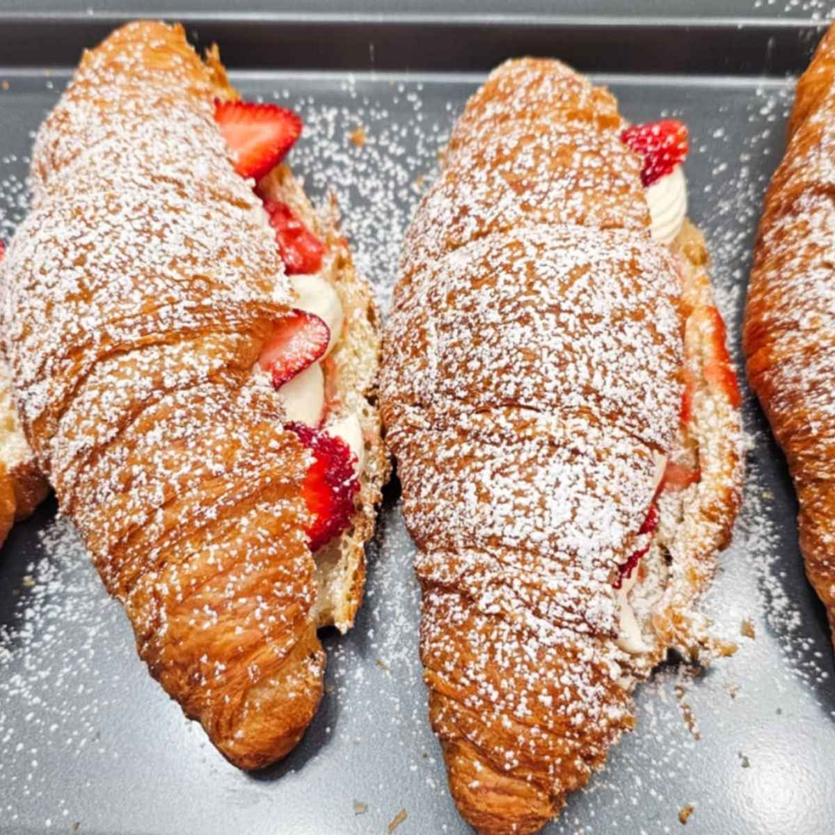 strawberry croissants with icing sugar on top