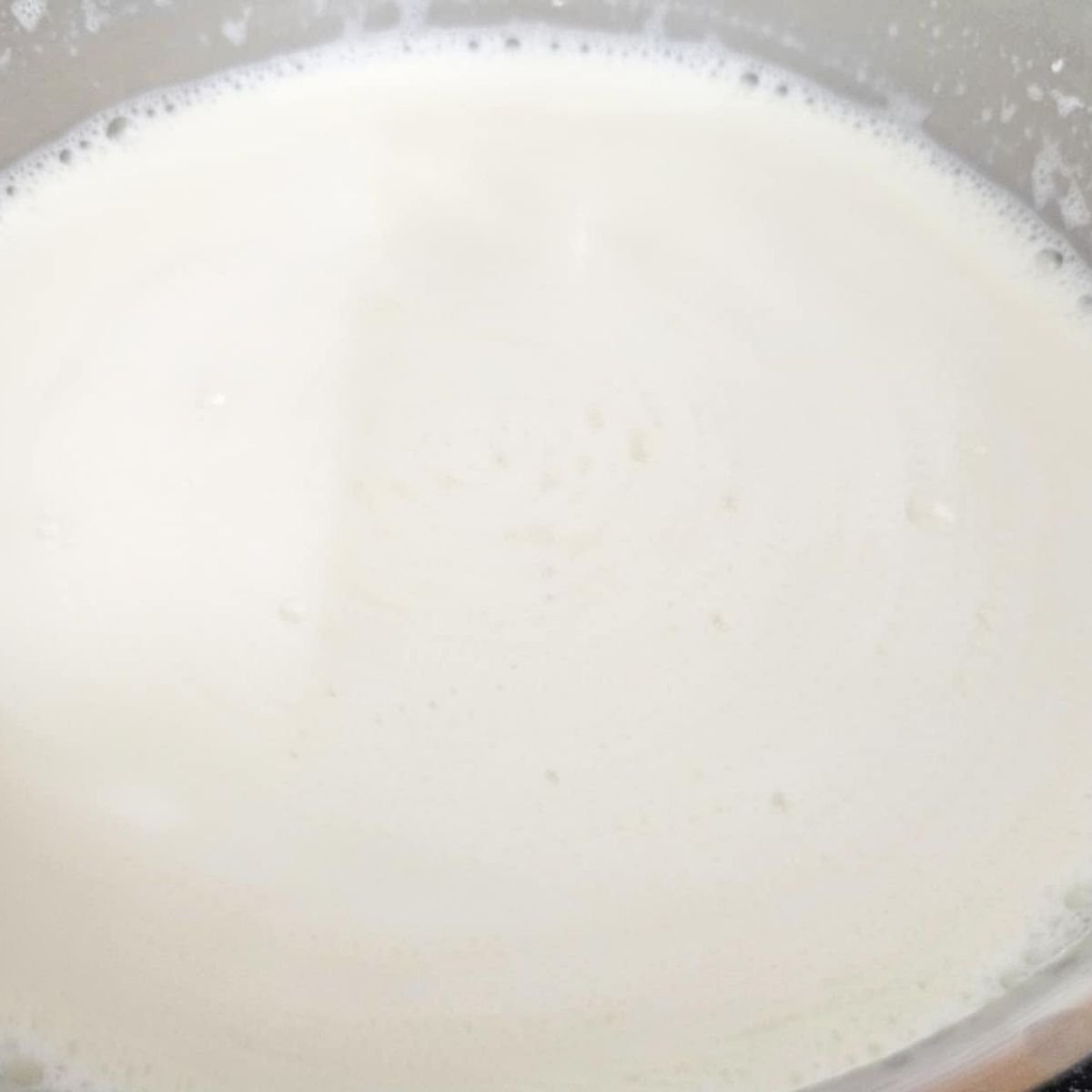 warmed milk in a stainless steel pot
