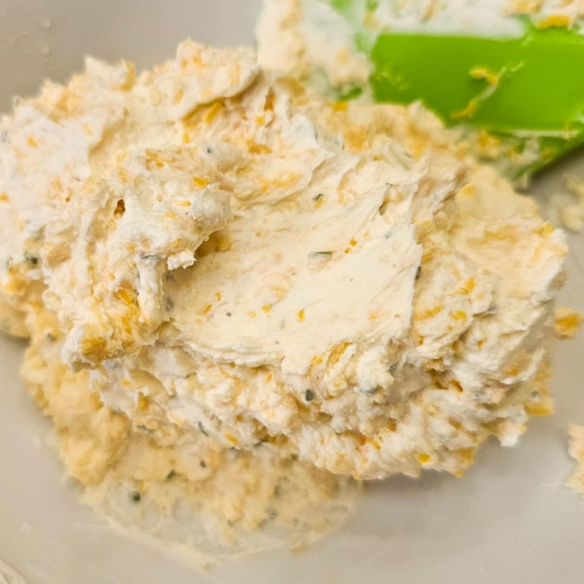 cream cheese, sour cream, shredded cheese and dried parsley in a bowl