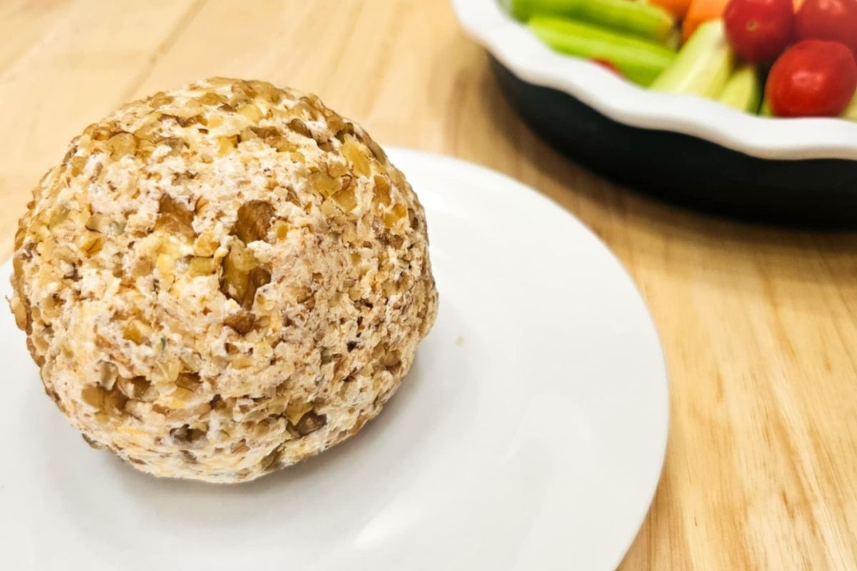 1950's Cheese ball on a white plate and wooden counter top