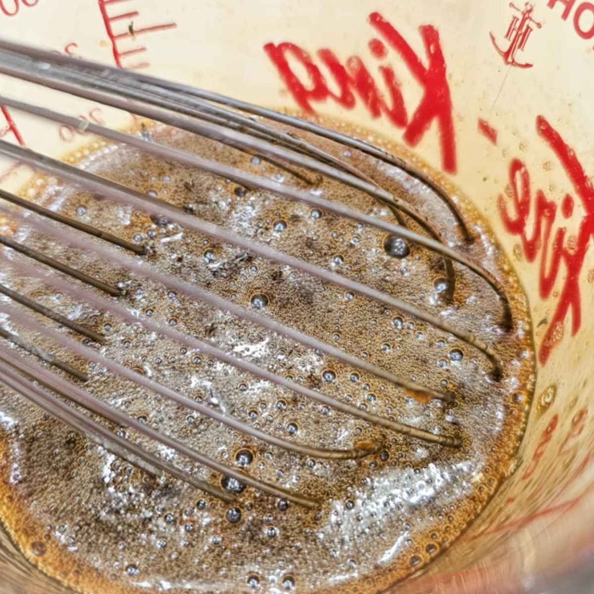 Olive oil being poured over the dressing to emulsify
