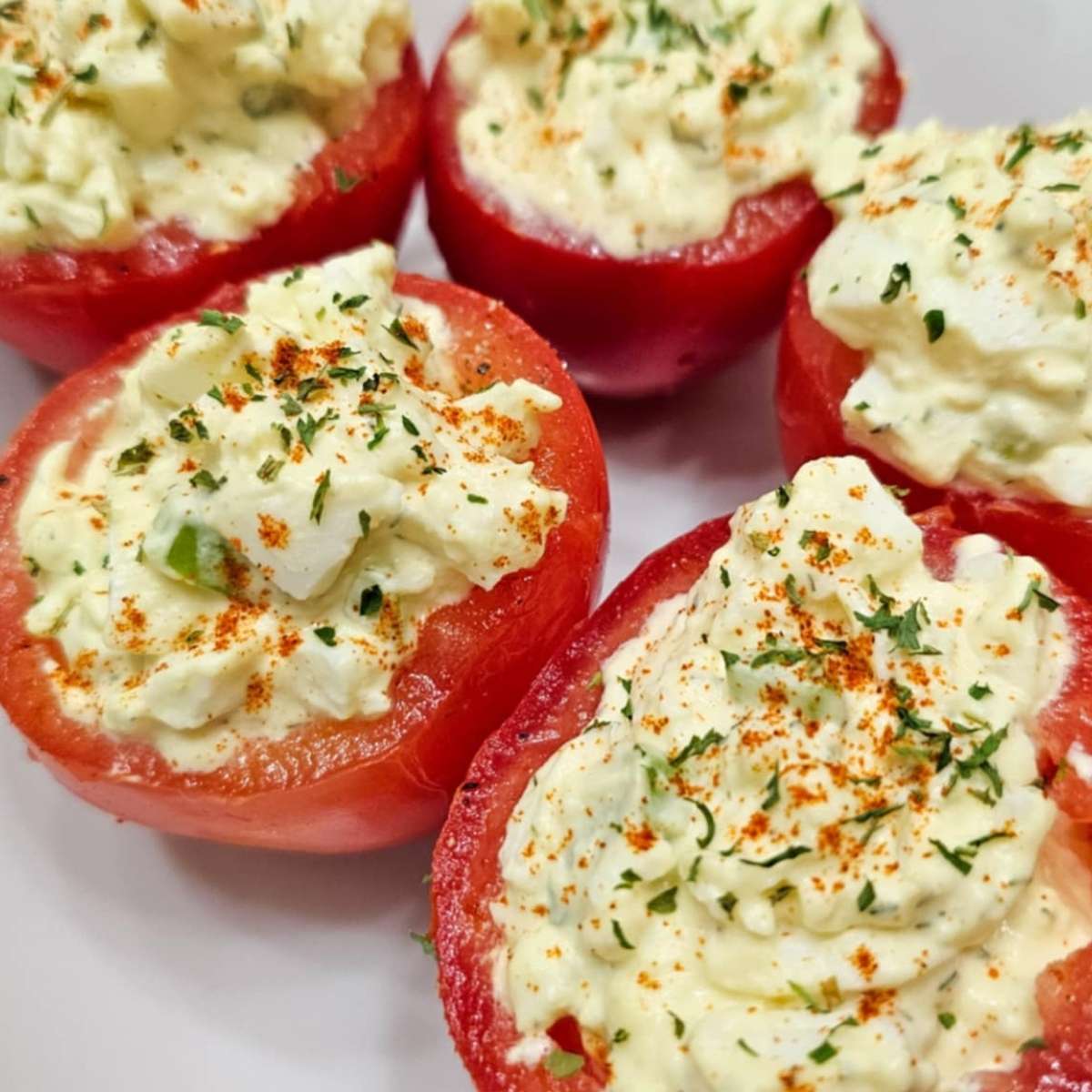 egg salad stuffed in tomatoes and garnished with paprika and dried parsley