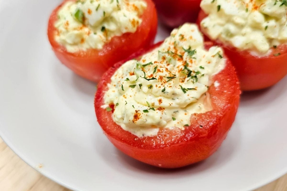 a close up of egg salad stuffed into a tomato