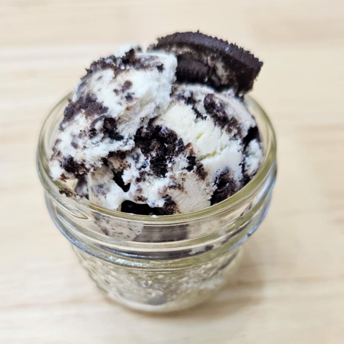 oreo ice cream in a mason jar on a wooden counter top
