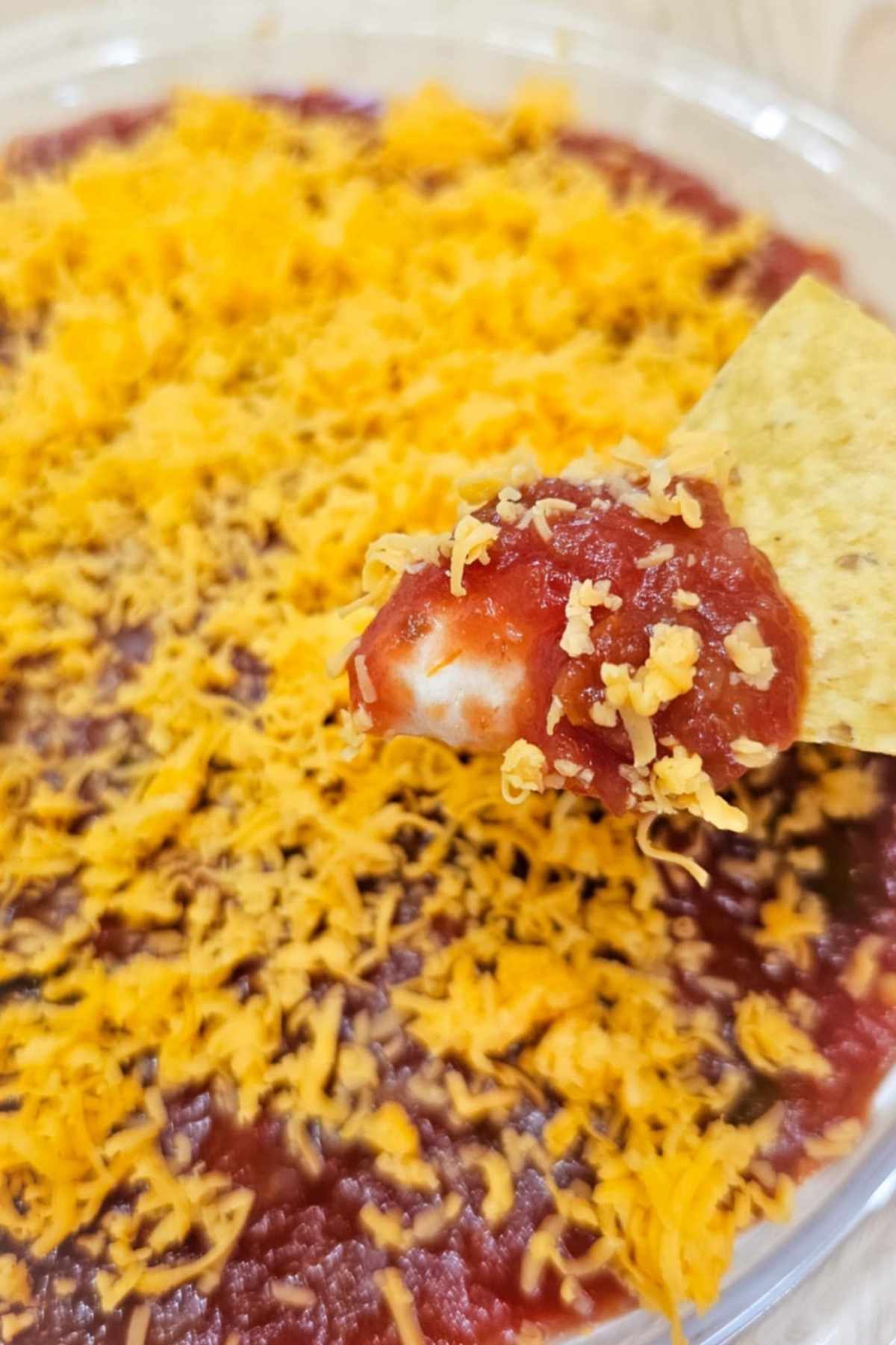 simple nacho dip with a corn chip dipping into it