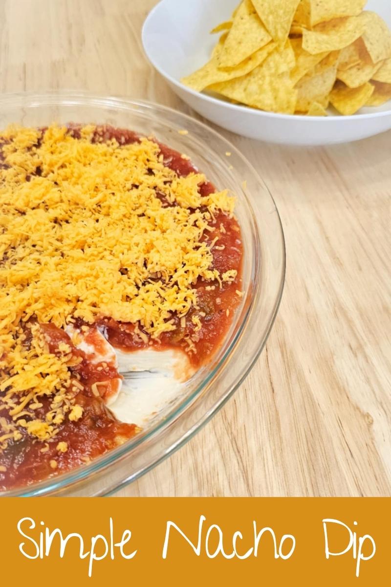 simple nacho dip in a shallow pie plate with corn chips in a bowl near it