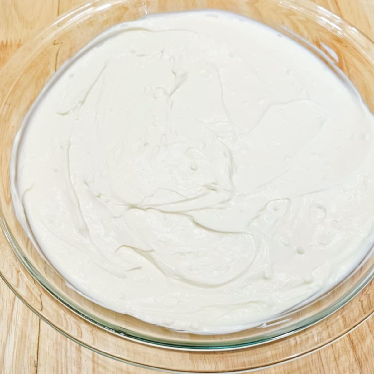 cream cheese and sour cream layer of the nacho dip in a pie plate