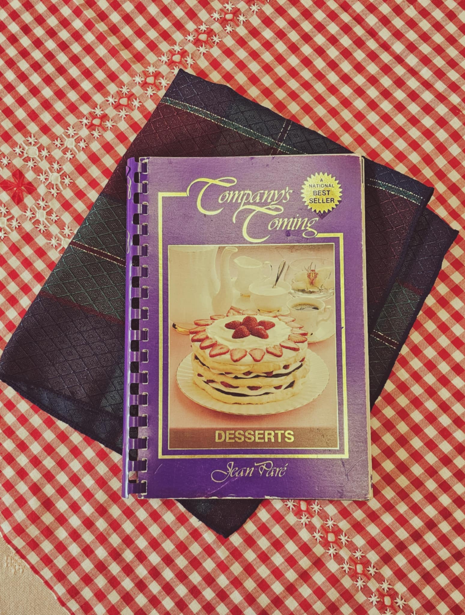 companys coming cookbook desserts by jean pare on a red and white plad table cloth