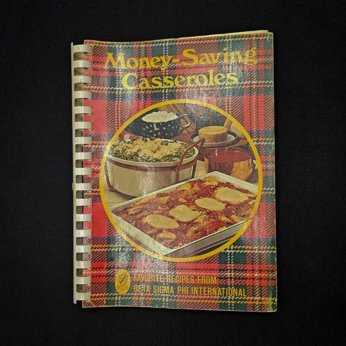 money saving casseroles from beta sigma cookbook on a black table cloth