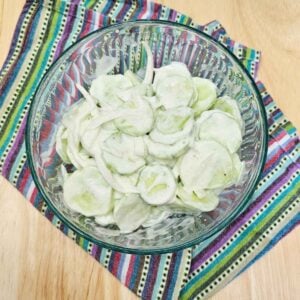creamy sour cream salad in a glass bowl on a colourful table mat on a wooden counter