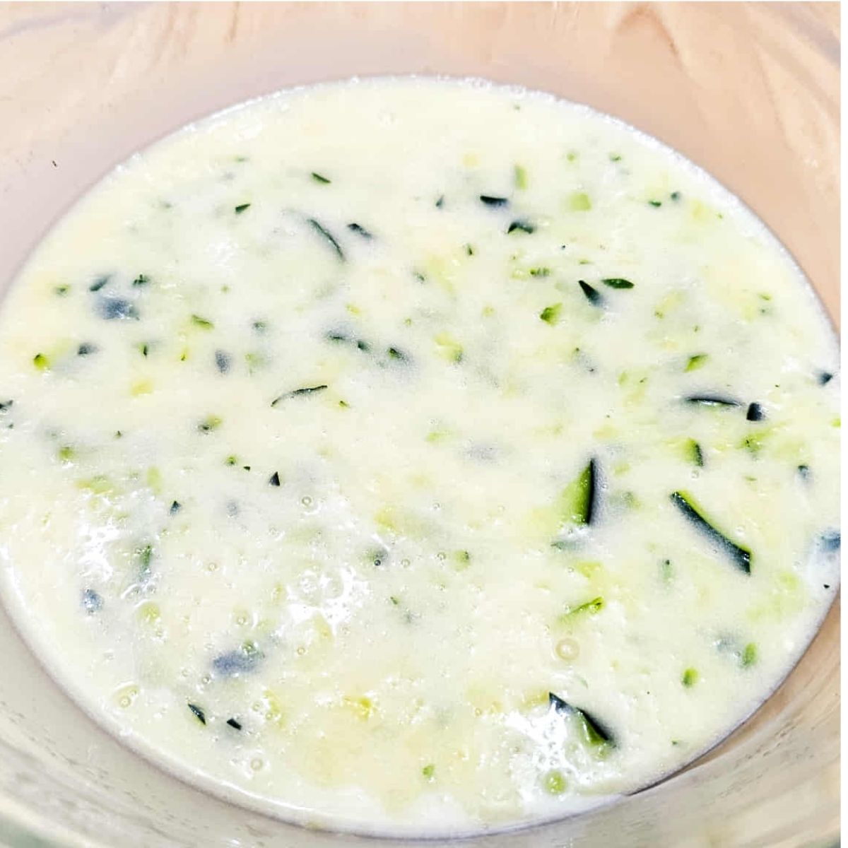 shredded zucchini added to the bowl of wet ingredients
