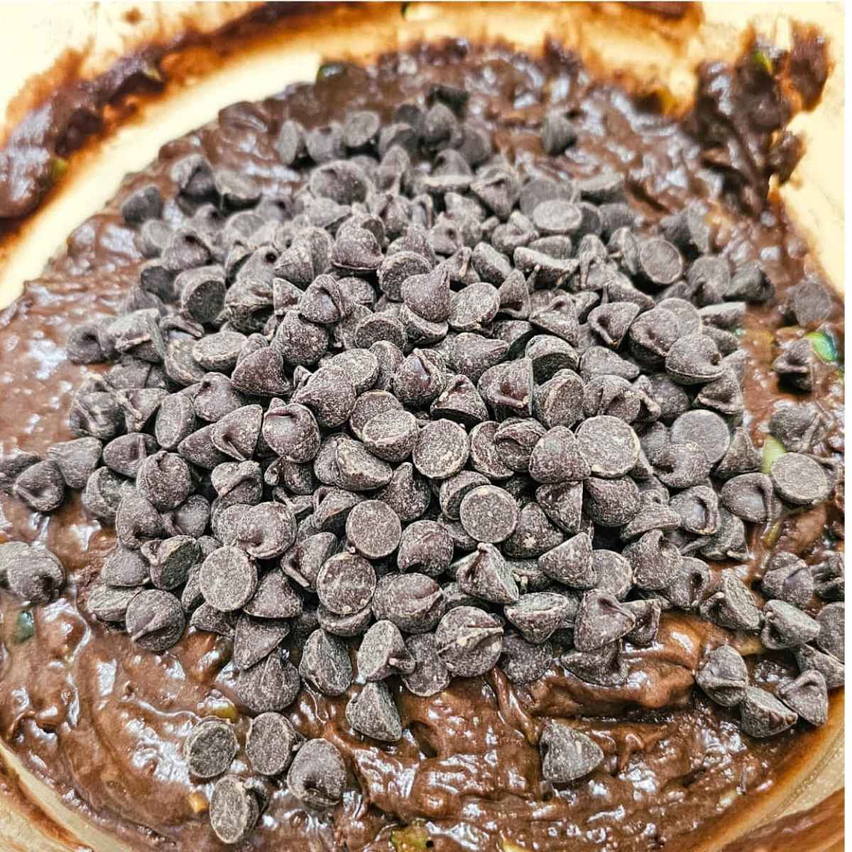 chocolate chips added to the batter in a glass bowl