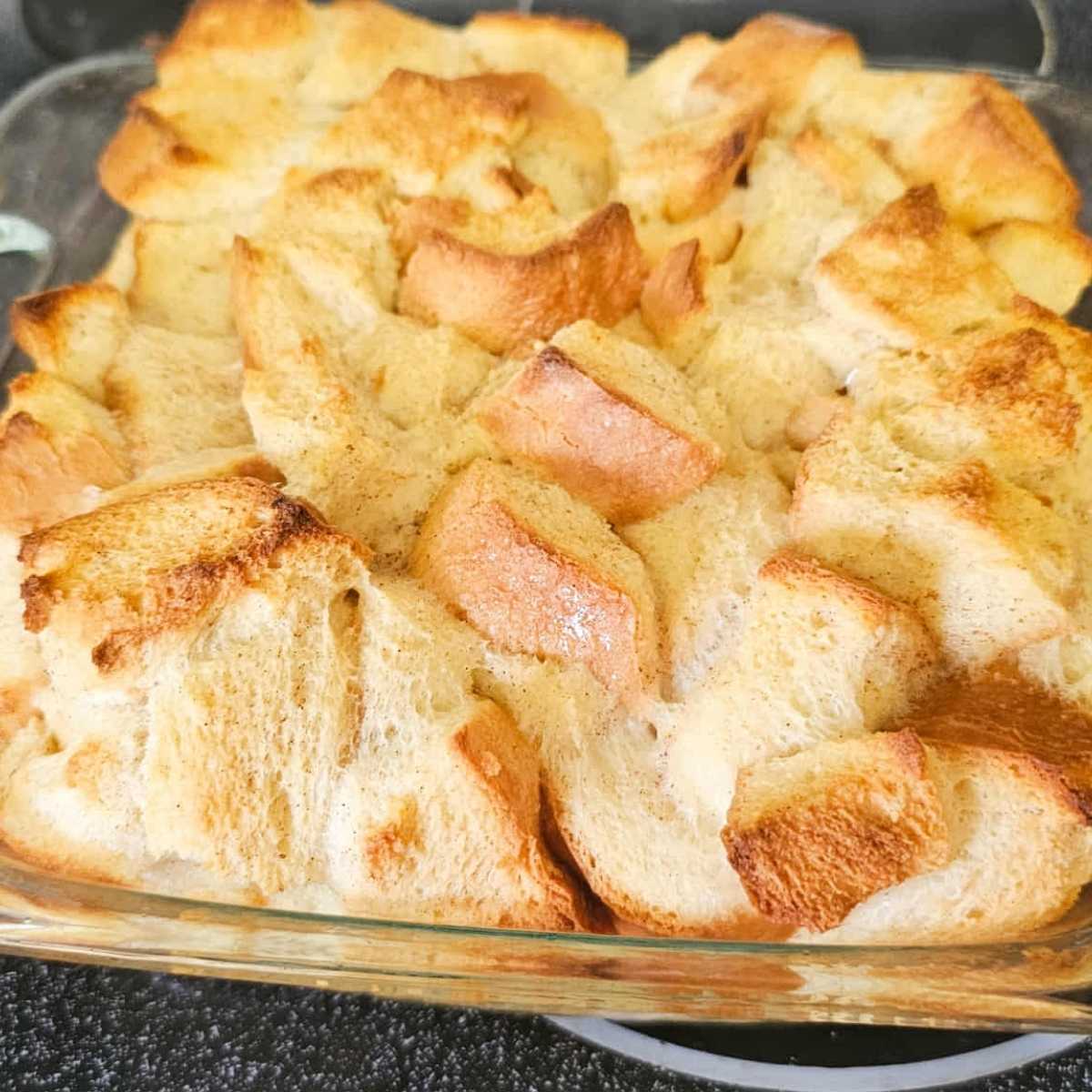 baked bread pudding sitting on a glass stove top oven