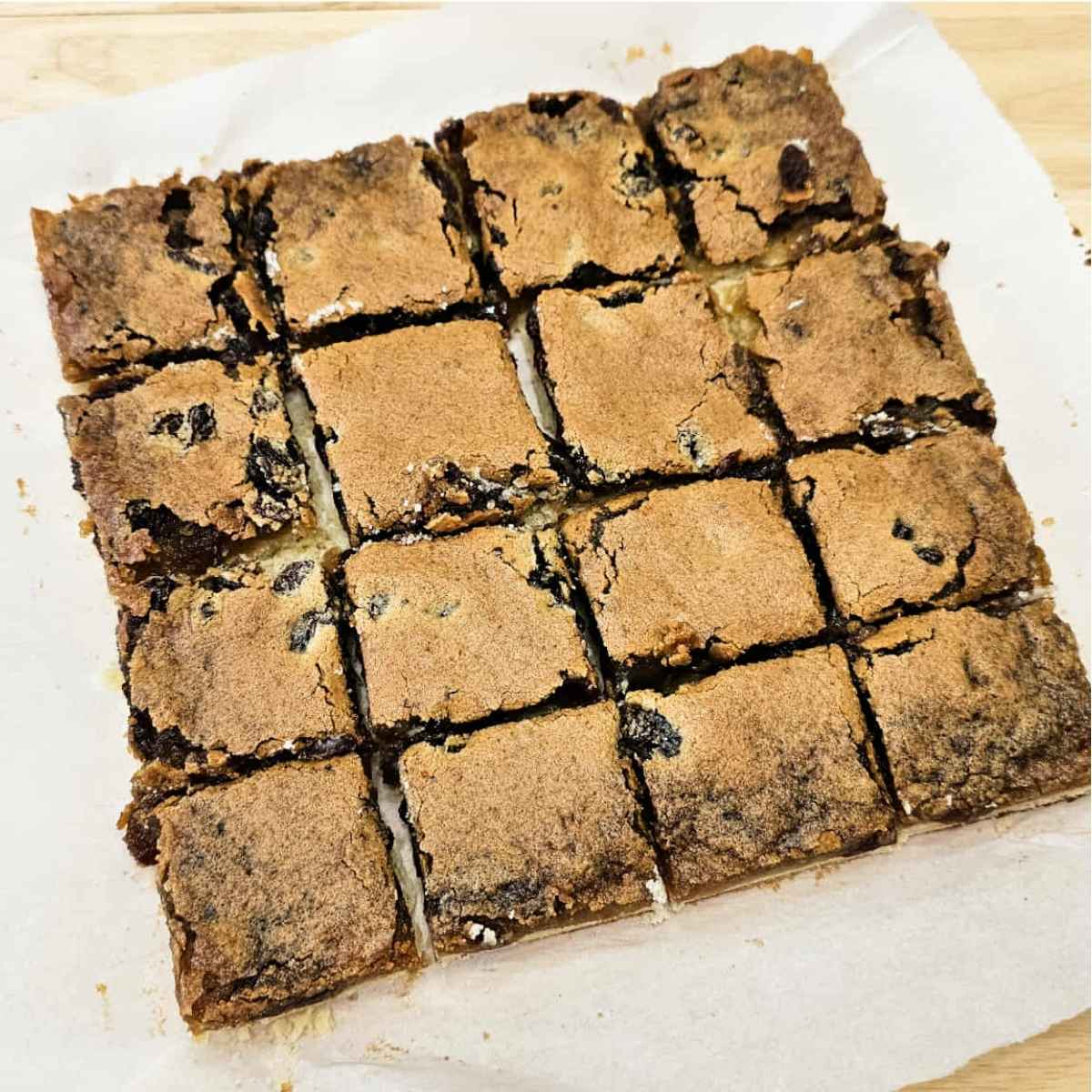 butter tart squares that have been cooled and sliced and sitting on a piece of parchment paper