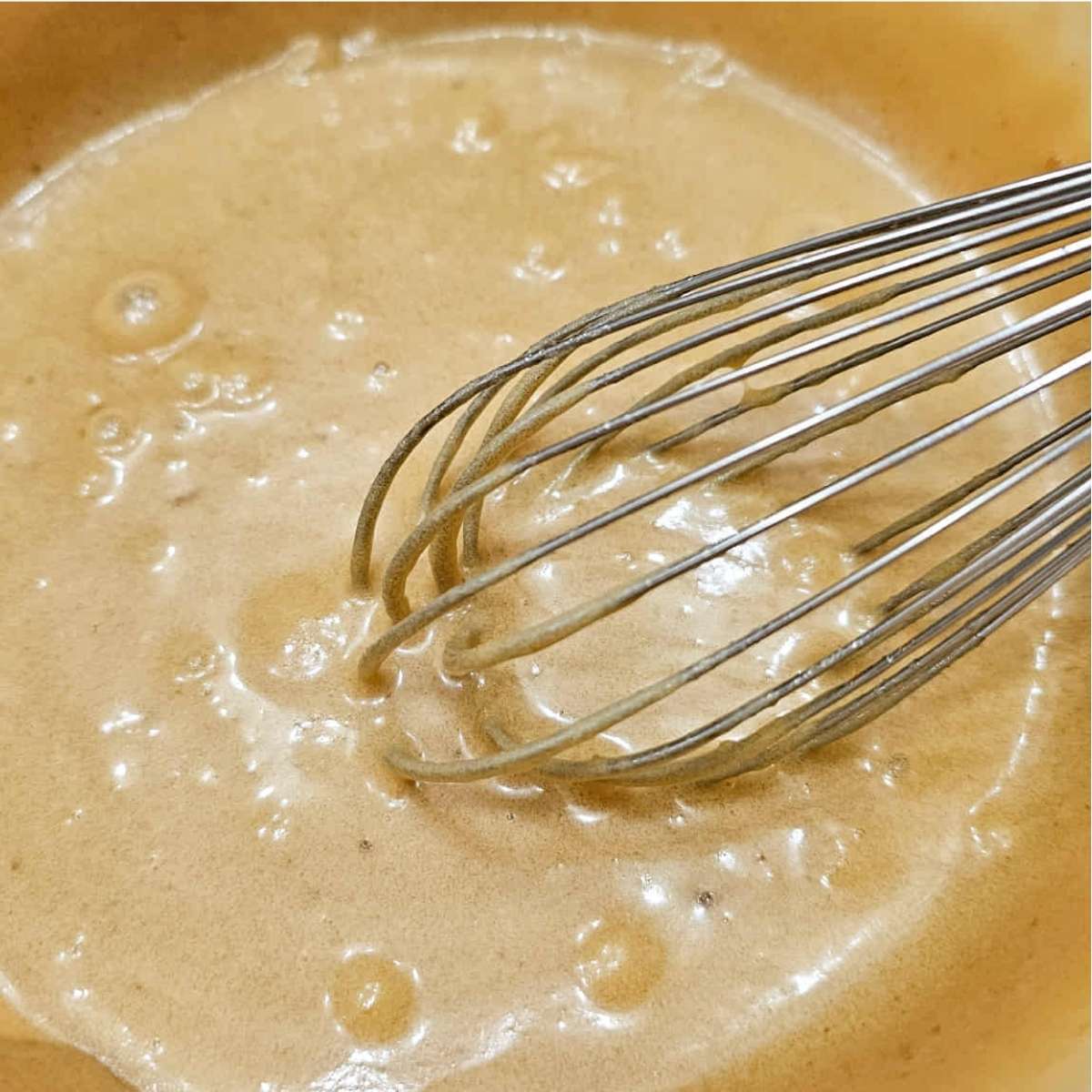 brown sugar, butter, eggs, vinegar and vanilla mixed together in a white glass bowl