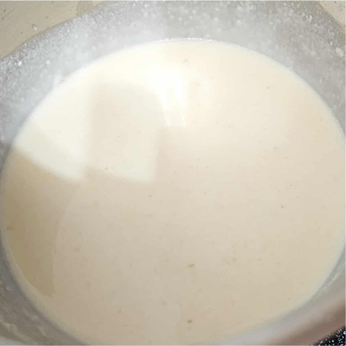 milk being added to the roux in a small pot