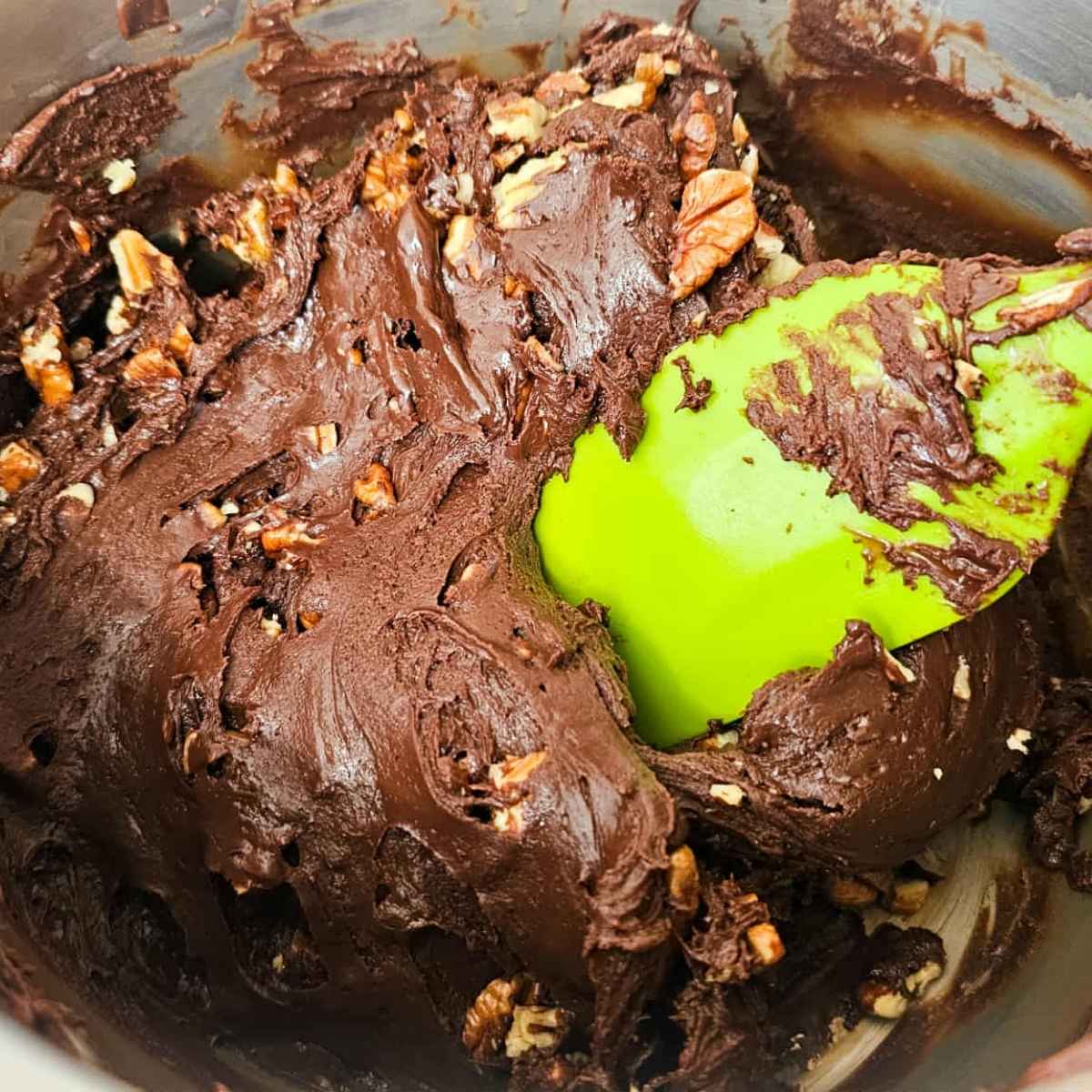 Pecans being added to the chocolate fudge mixture.
