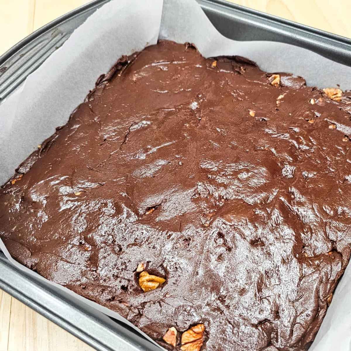 chocolate pecan fudge in a 9x9 parchment lined pan