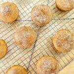 cinnamon sugar muffins on a wire rack cooling on a wooden table