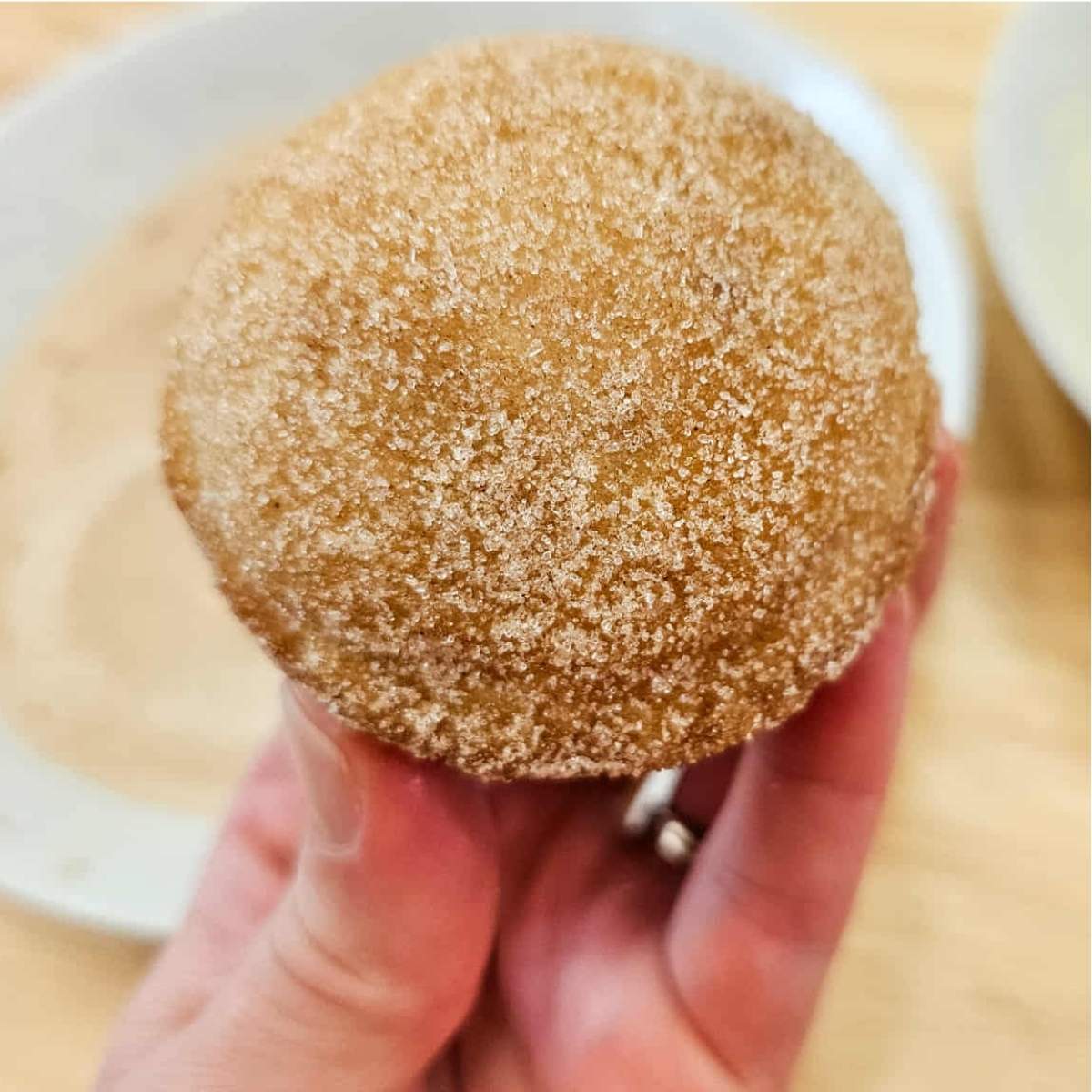 muffins dipped in butter and then cinnamon sugar and being held with the happy homemakers hand