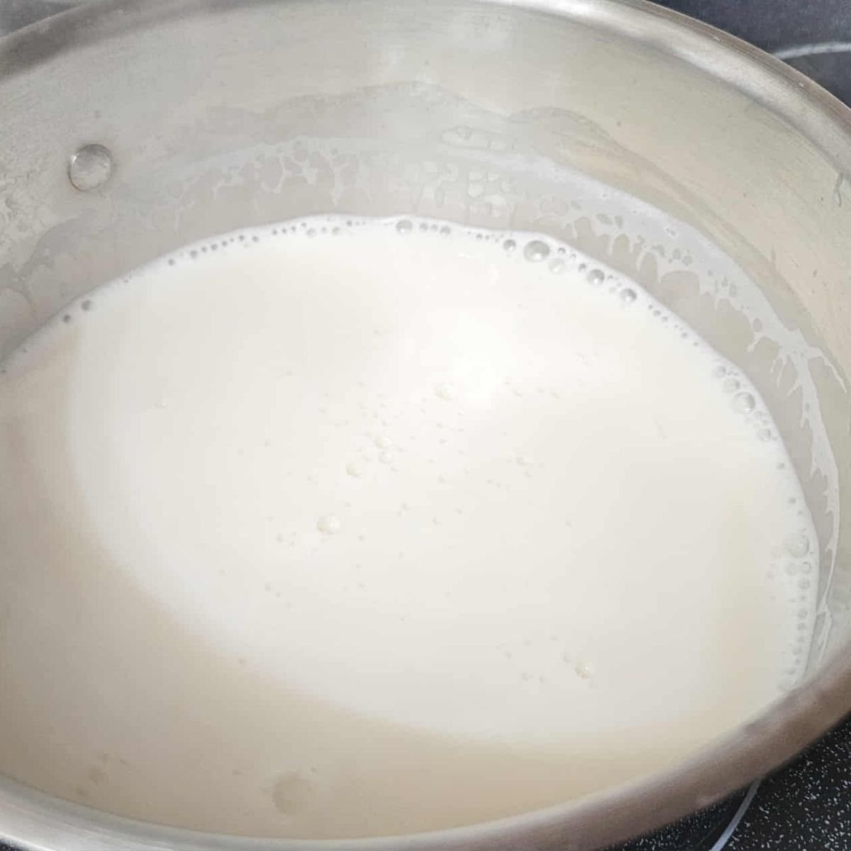 hot maple milk in a stainless steel pot that was just heated through and frothy