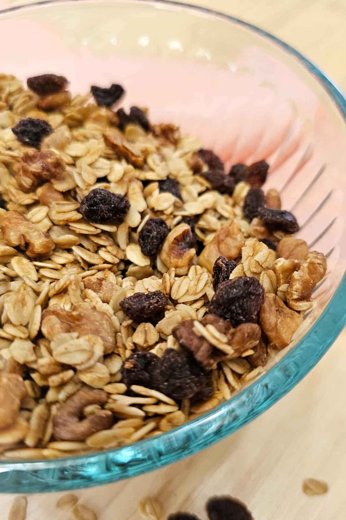 a close up picture of maple walnut granola in a clear glass bowl