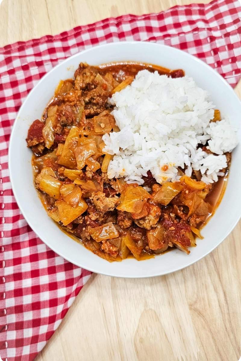 unstuffed cabbage rolls in a white bowl on a wooden counter top with a cloth napkin