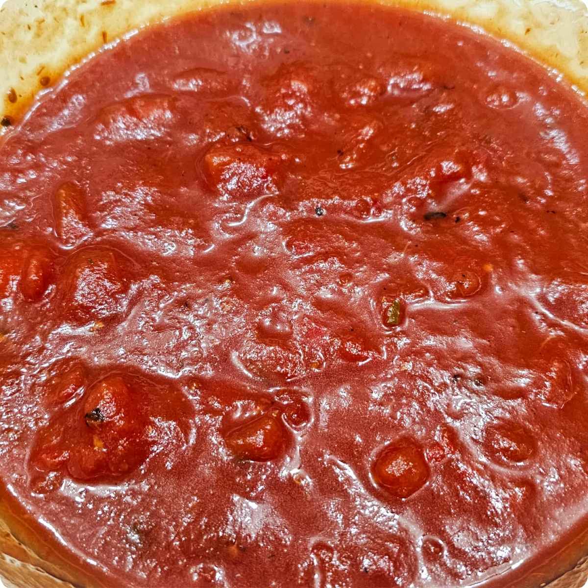 diced tomatoes, tomato sauce, Worcestershire sauce, brown sugar, Italian seasoning, parsley, garlic powder, salt, pepper and water in a bowl being mixed
