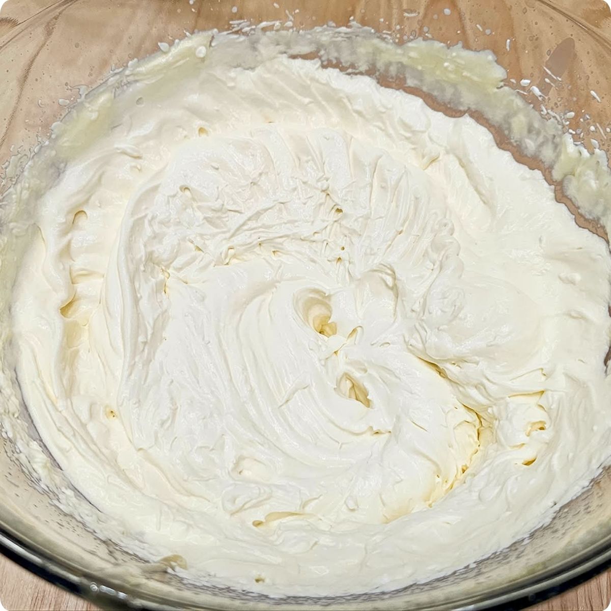 whipped cream in a bowl sitting on a wooden counter top