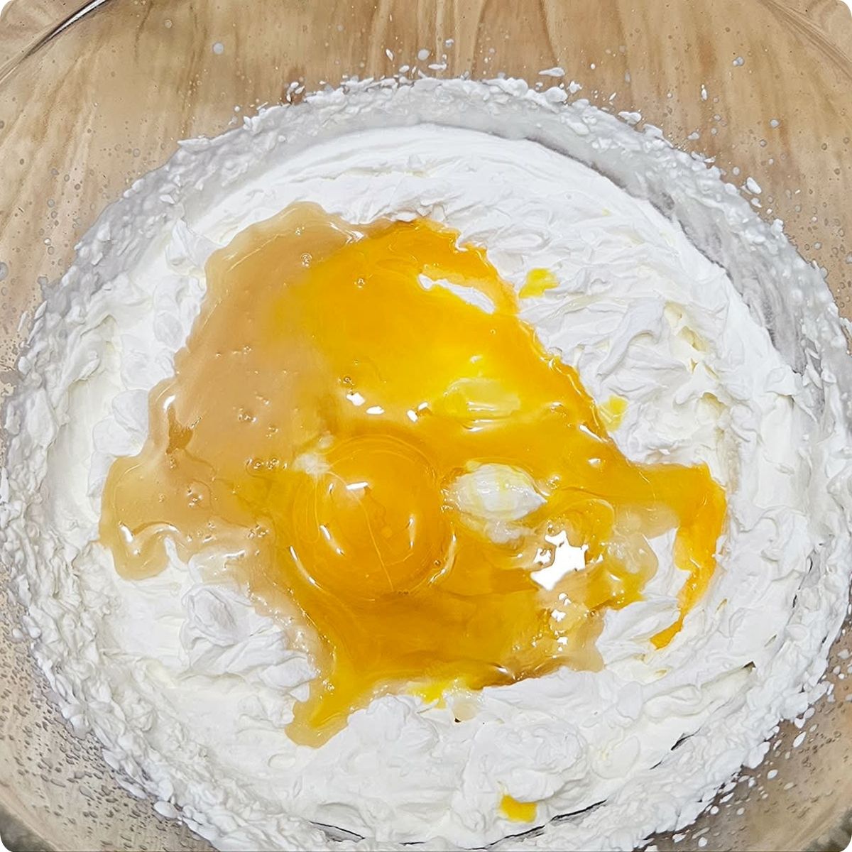 whip cream, honey and vanilla sitting in a clear glass bowl on a wooden counter top